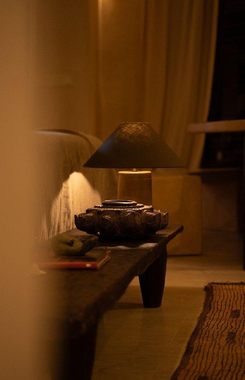A lamp lit in a plaster alcove, in the evening